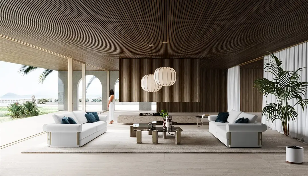 White sofas facing each other under a slatted timber ceiling, with arches open to the sea
