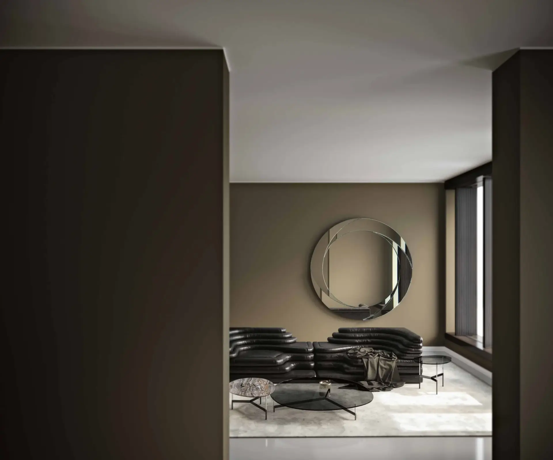 Dark armchairs and a round mirror in a room with tall timber doors