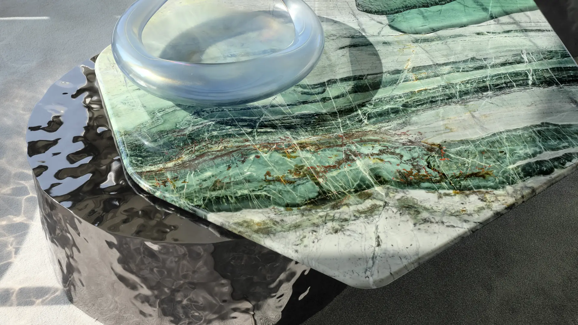 Green marble tabletop and a glass ring resting on a hammered metal base
