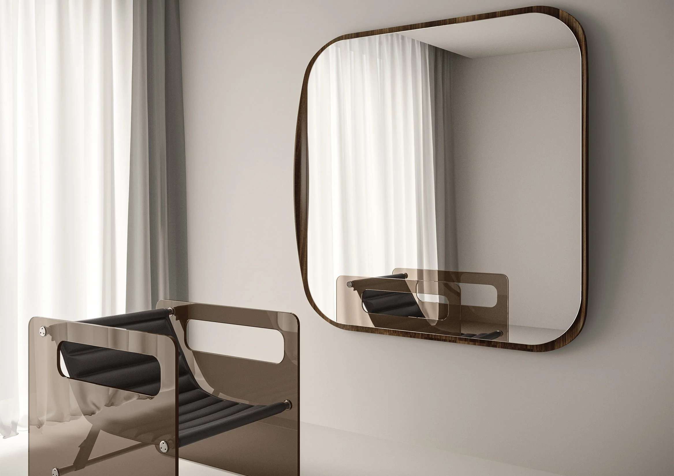 Rounded mirror with a bronze frame above a curved chair in a pale room