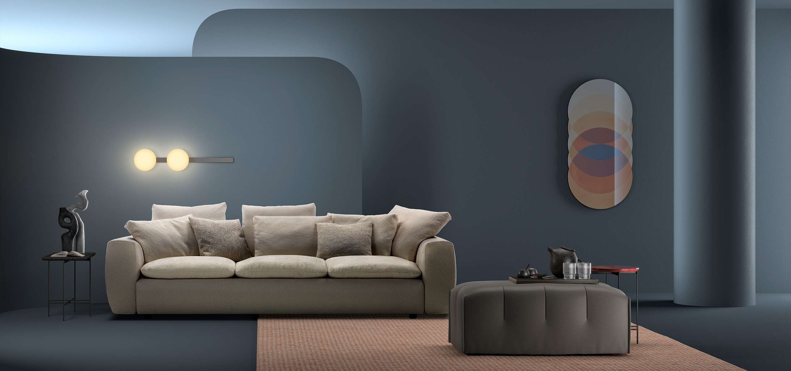 Cream sofa and a grey pouf against a deep blue wall with an oval mirror