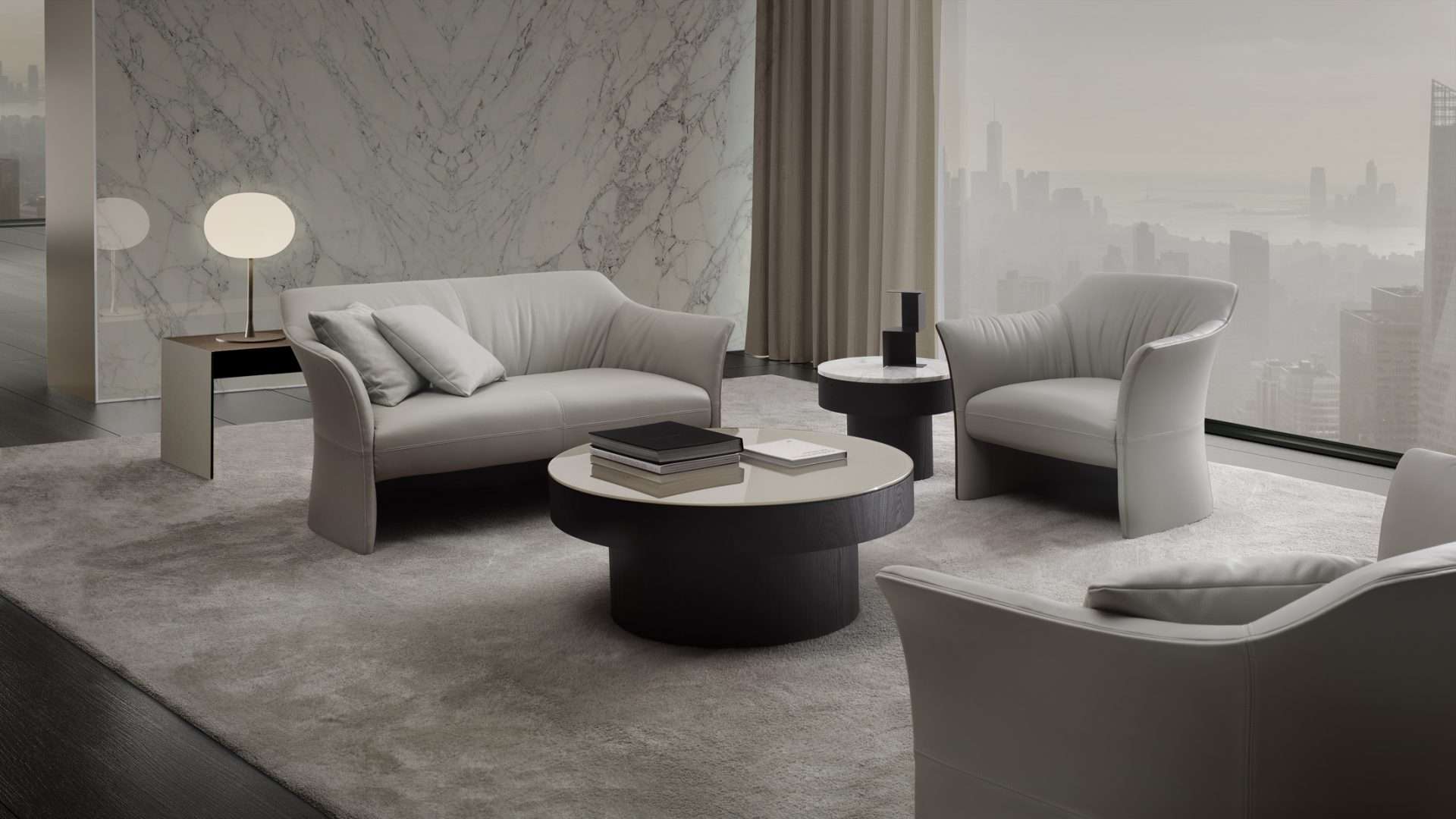 Grey leather sofa and armchair around round tables before a marble wall