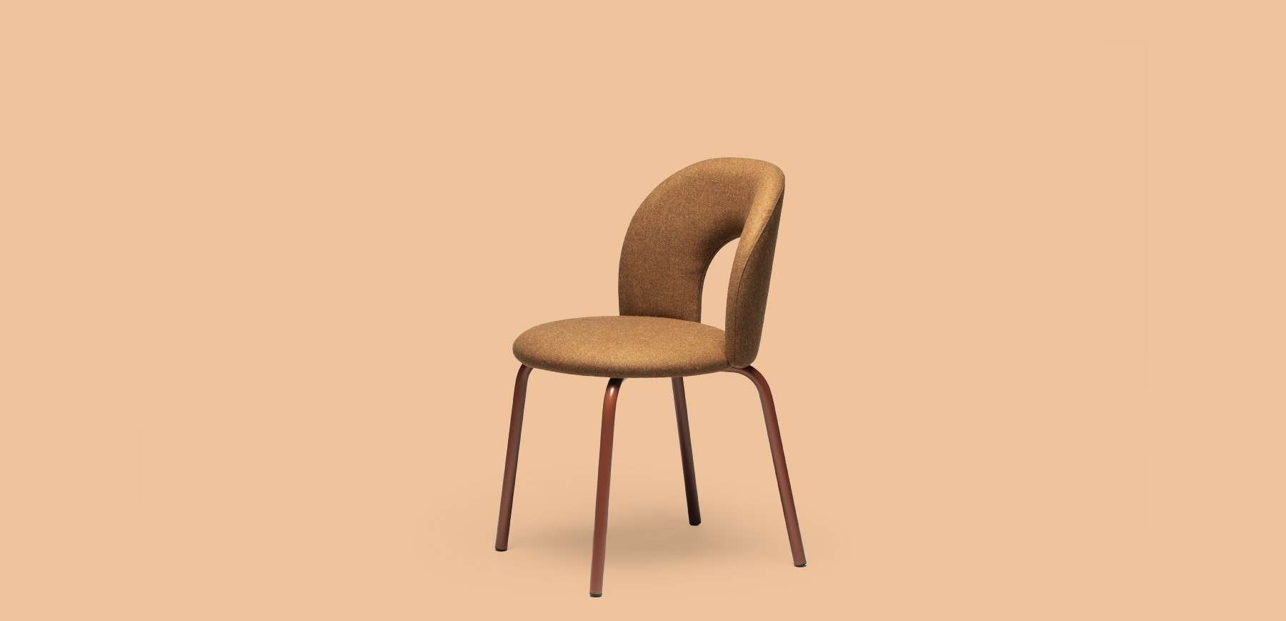 Tan upholstered chair on slim legs against a peach background