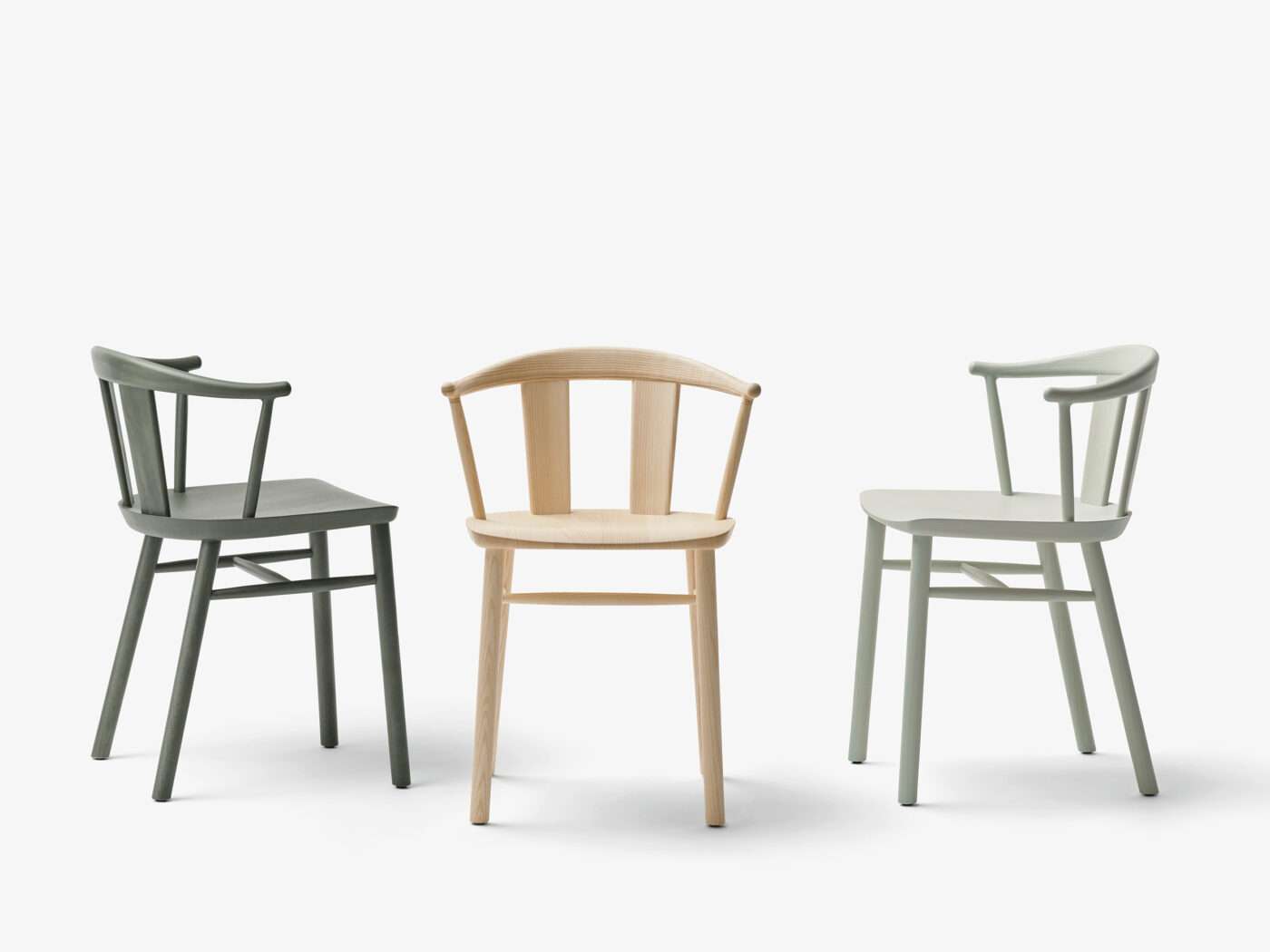 Three wooden armchairs with curved backs in different finishes