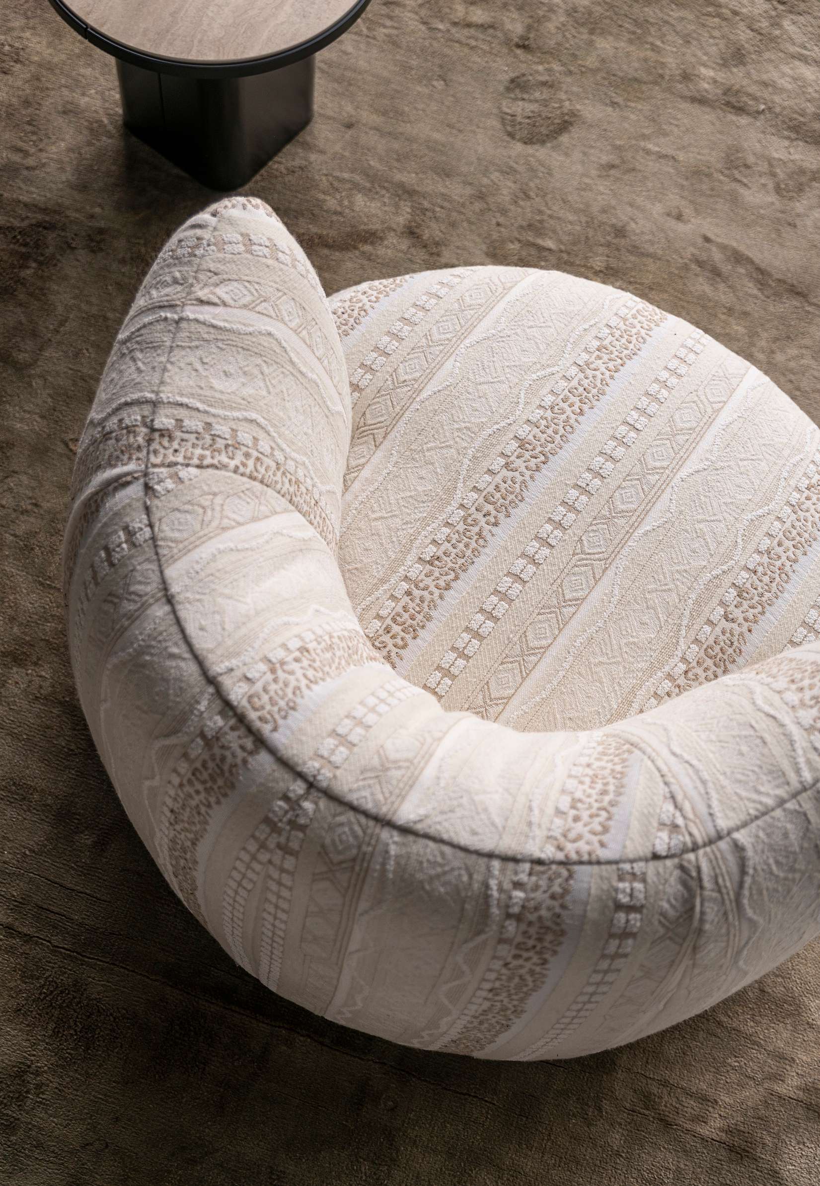 Close-up of a rounded seat in textured ivory fabric
