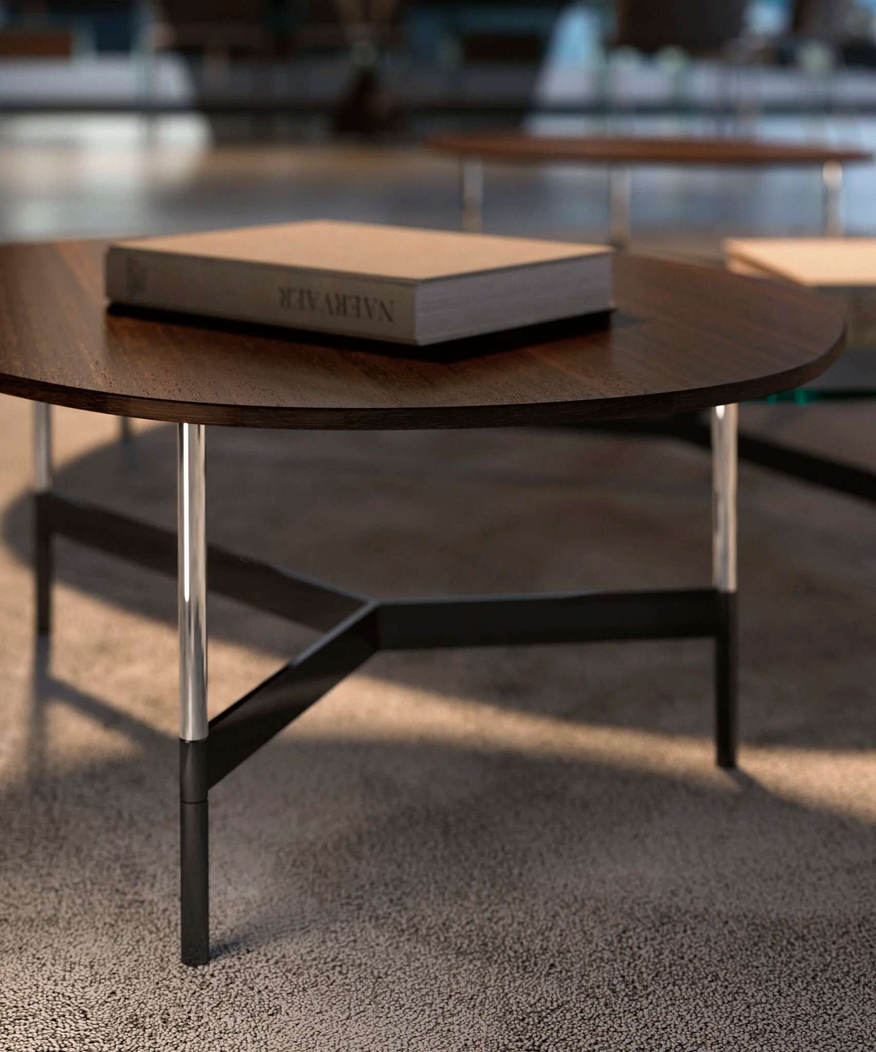 Round table with a walnut top on slim metal legs, close up