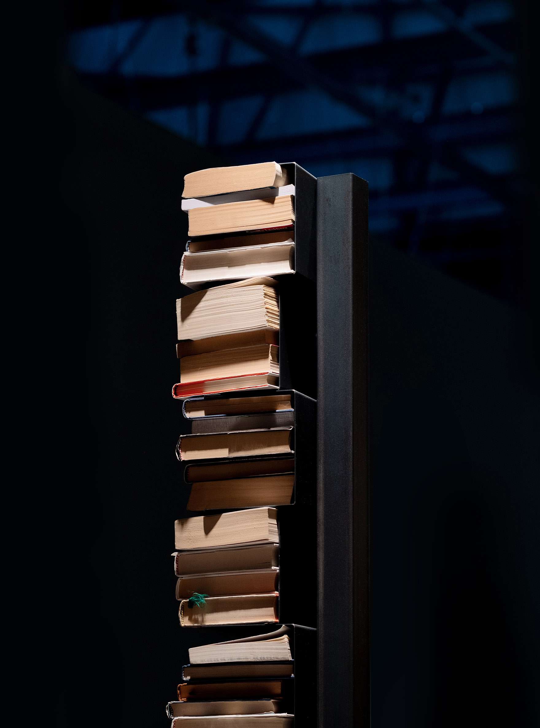 Column of stacked books held by an almost invisible bookshelf