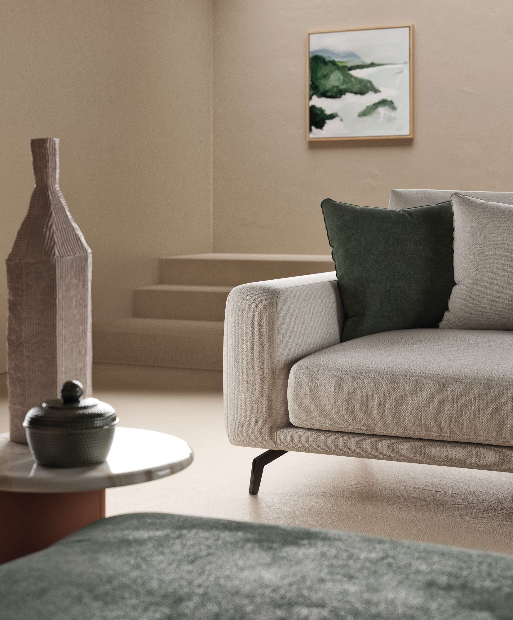 Corner of a pale sofa with a dark green cushion beside a stone sculpture