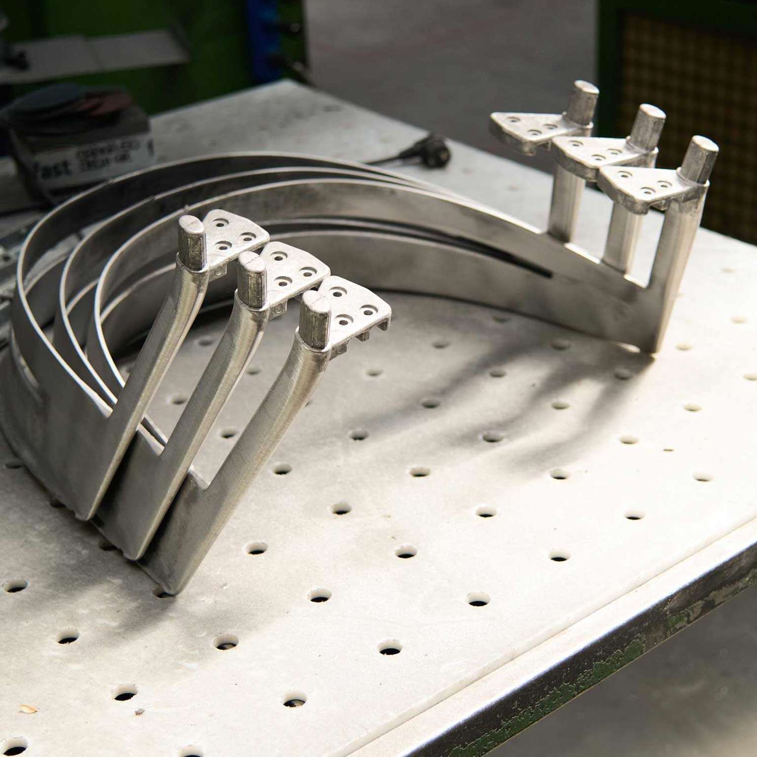 Cast aluminium chair parts lined up on a workbench