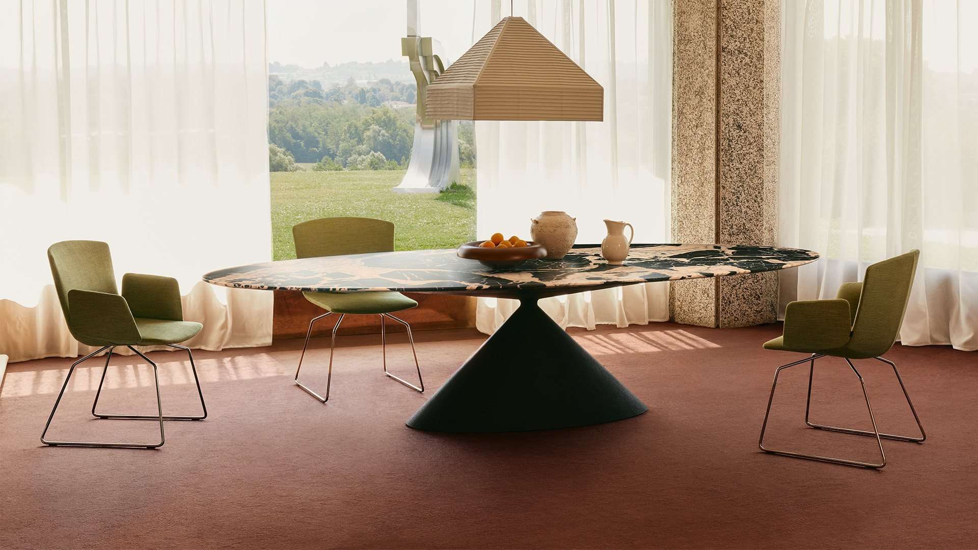 Marble-topped dining table on a black cone base beneath a paper pendant