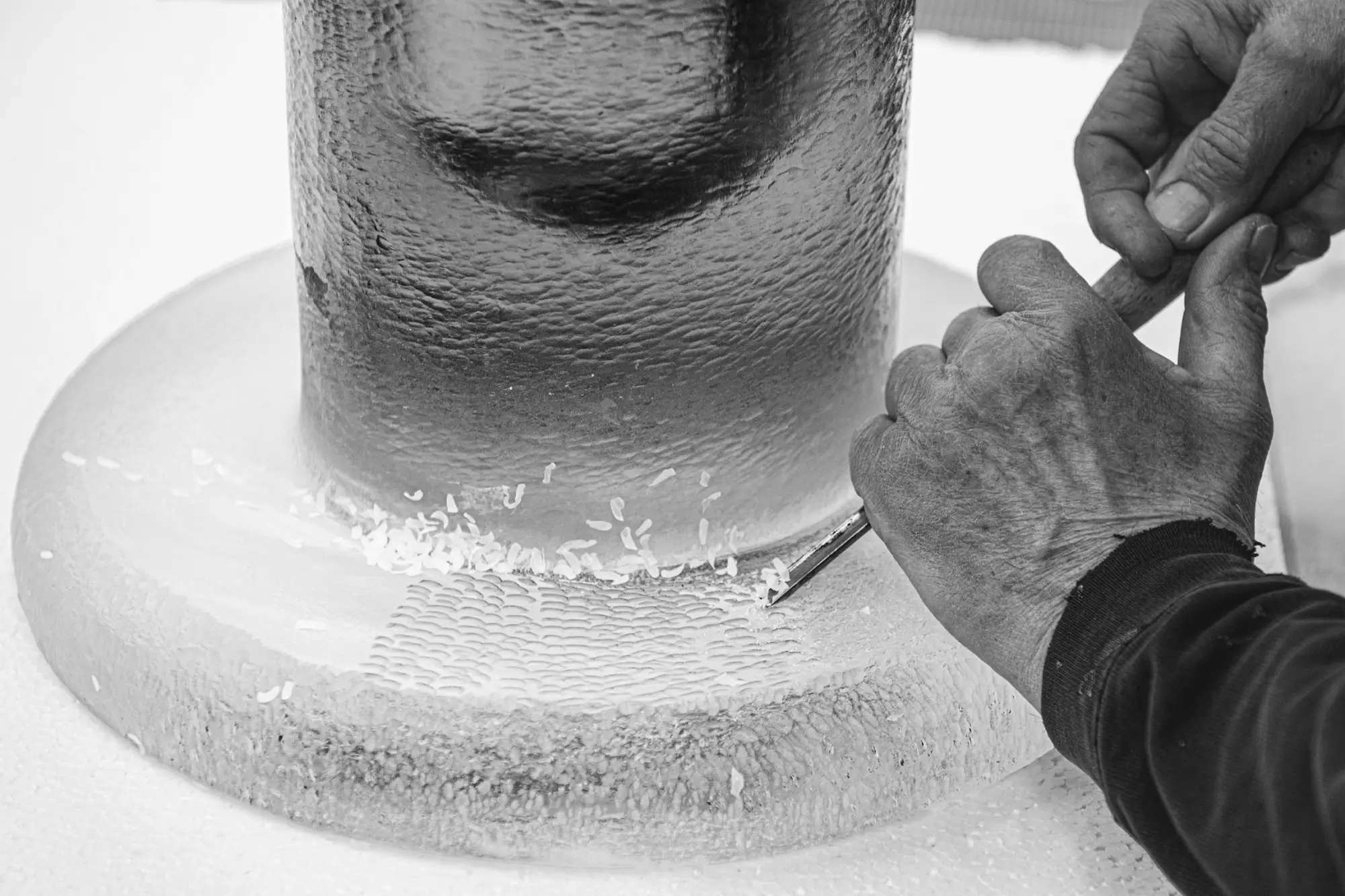 Hands finishing the rim of a glass table base