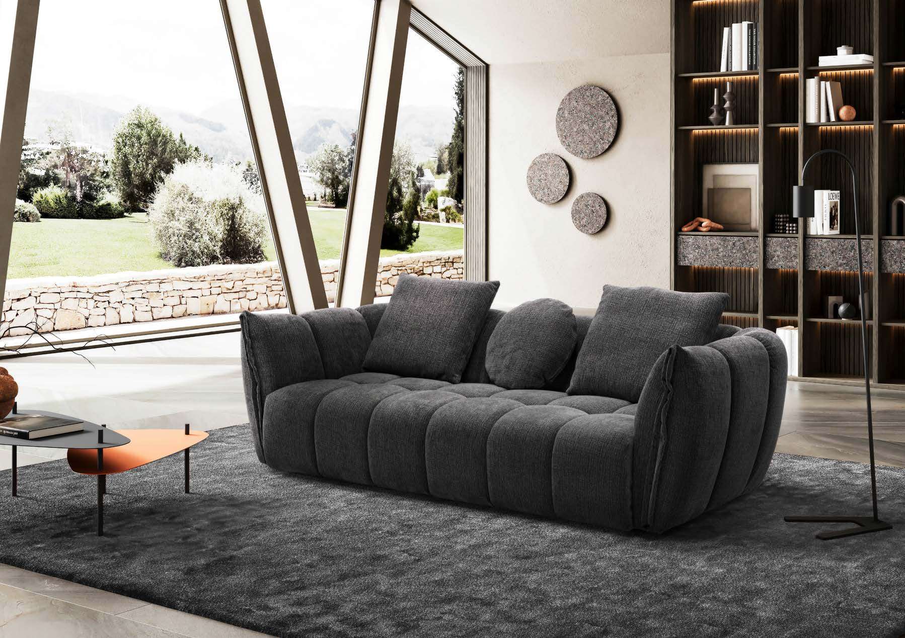 Charcoal channel-quilted sofa in a room opening onto a garden