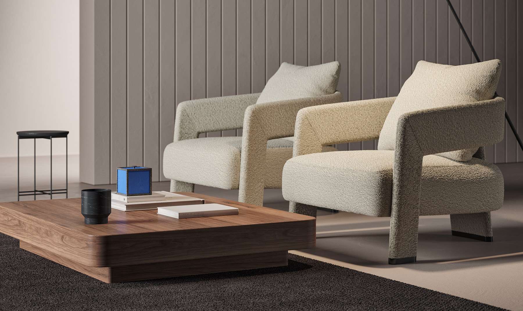 Two cream armchairs and a low walnut table before ribbed walls
