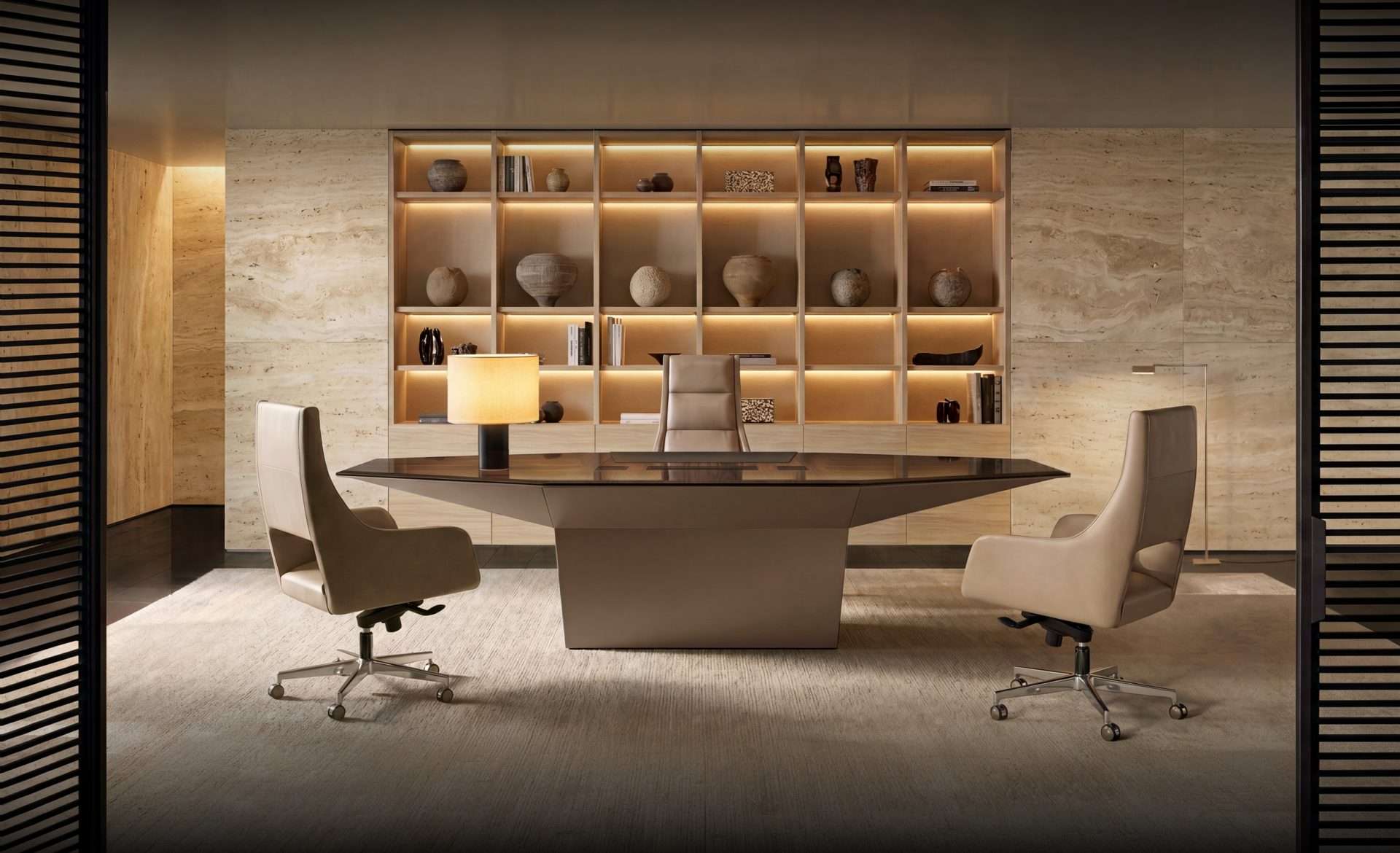 Executive office with a stone meeting table and a lit bookcase