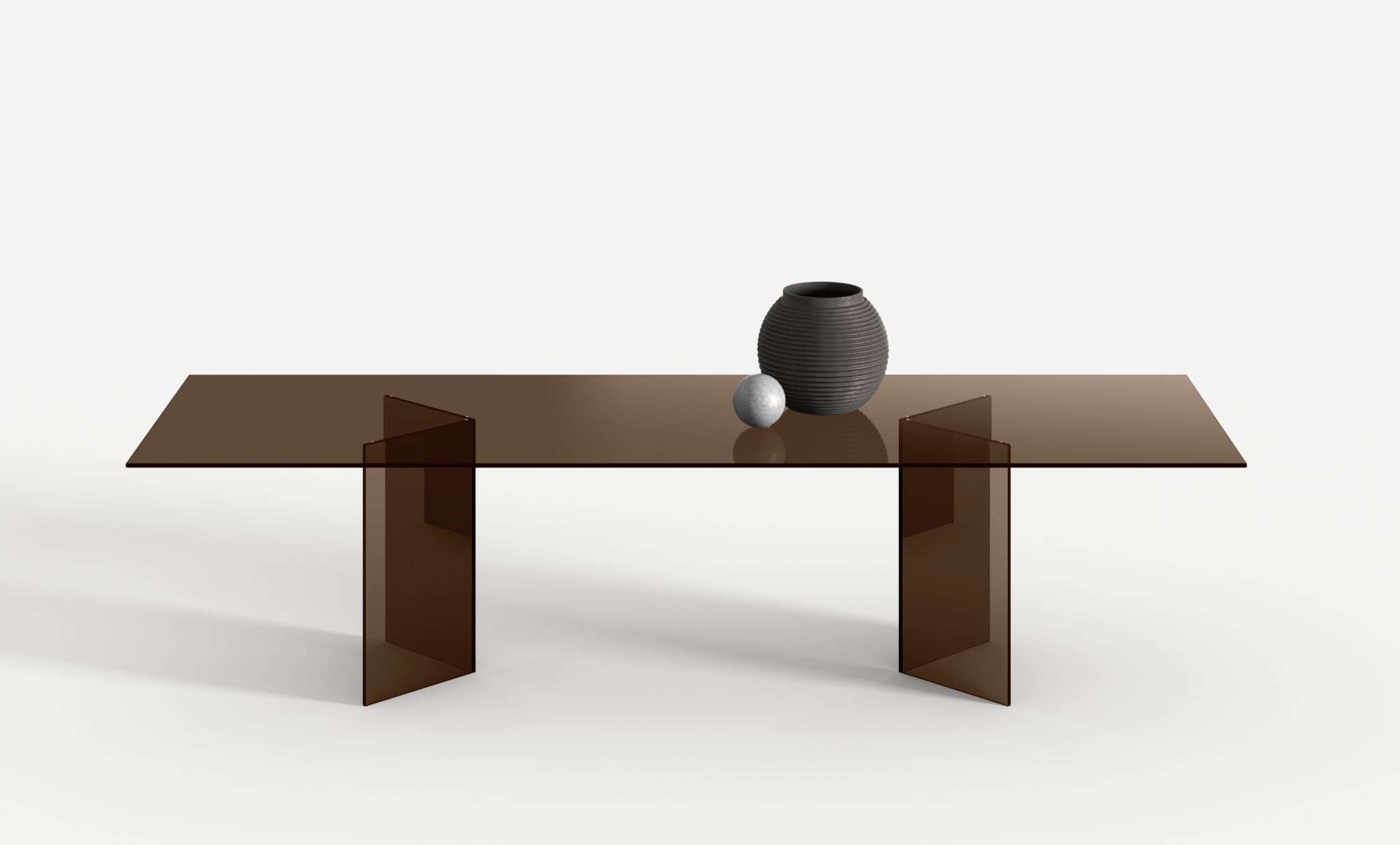 Bronze glass dining table with angled glass legs and a dark vase