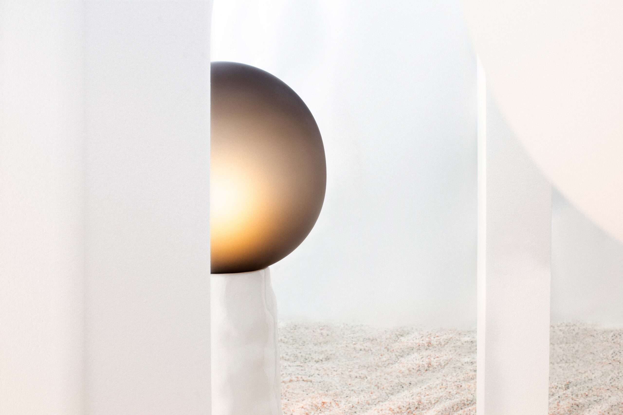 Amber glass globe lamp glowing against a white wall