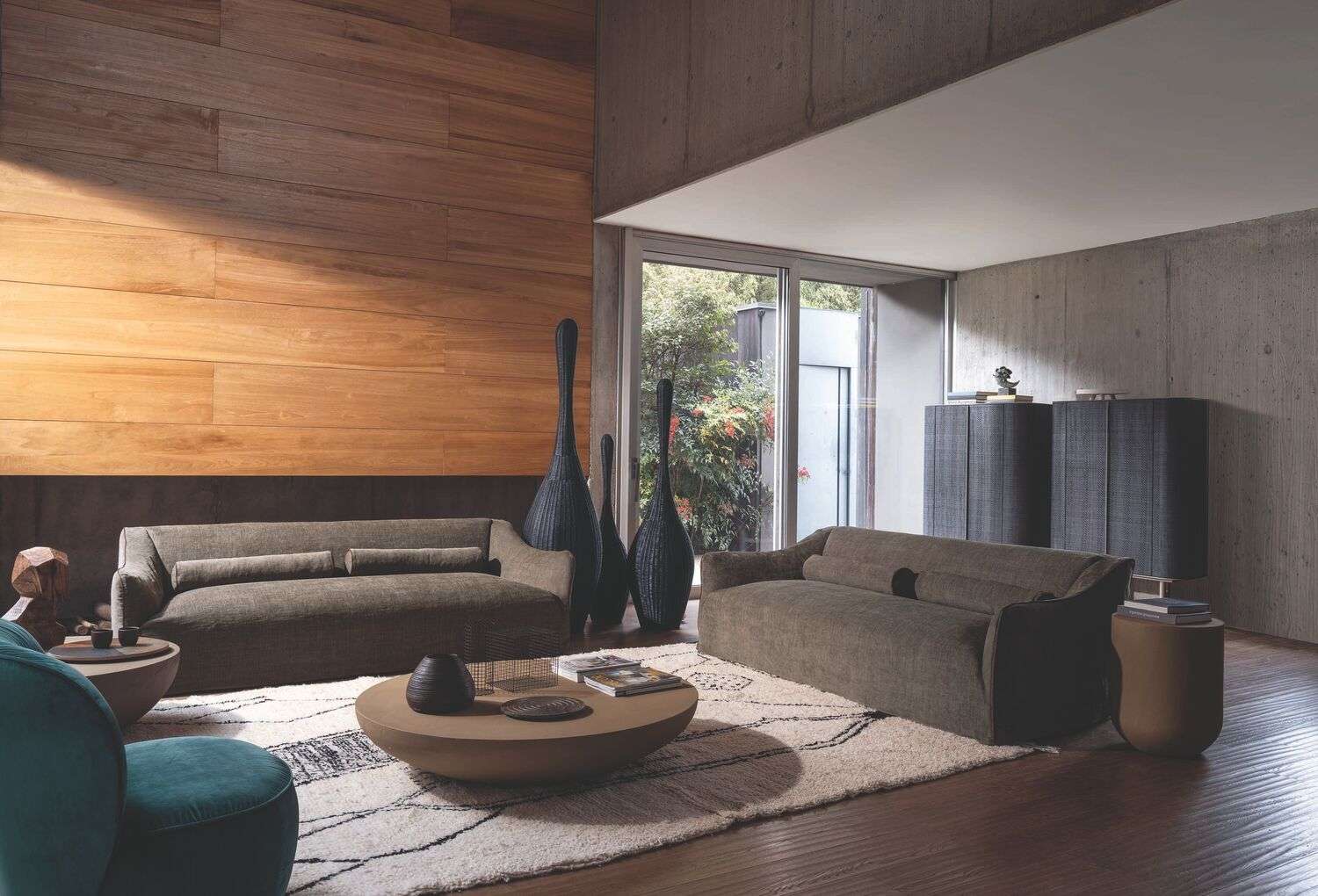 Low sofas and a round coffee table against a warm timber wall