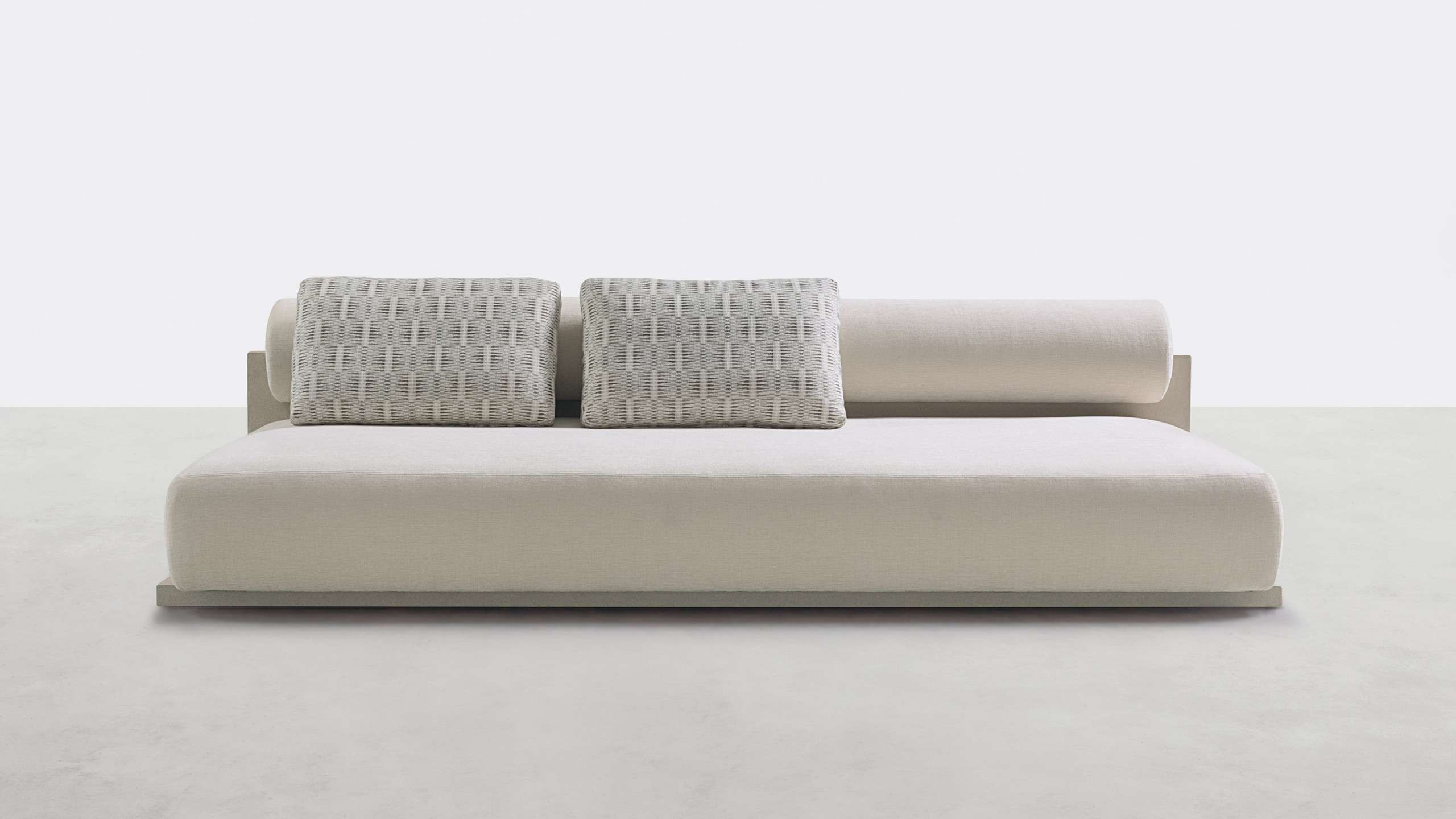 Long ivory sofa with woven cushions and a bolster