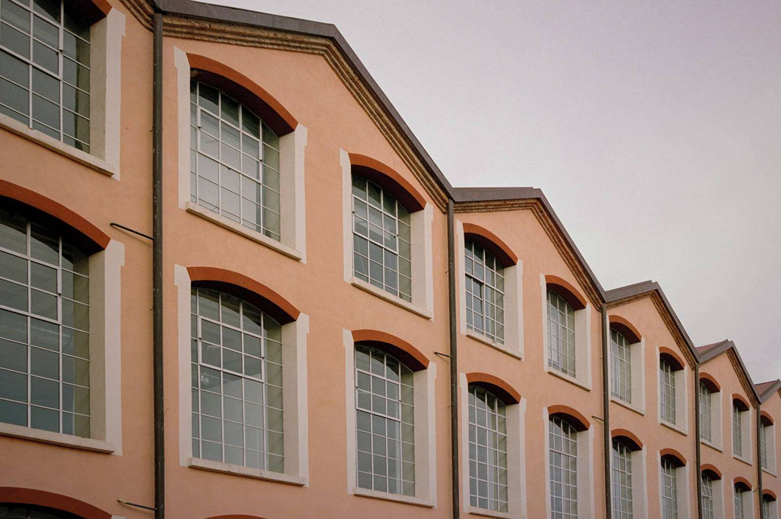 The long ochre factory building with arched windows
