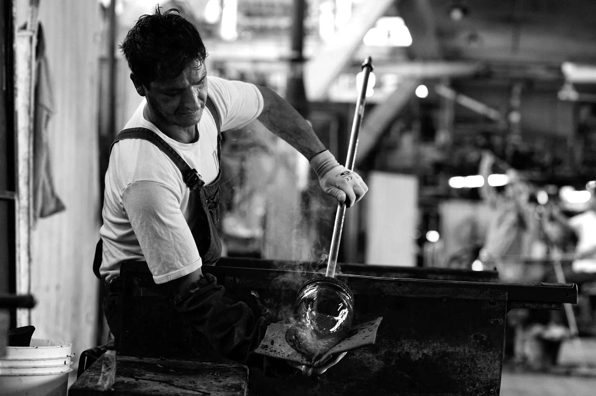 A glassmaker at work in the factory, in black and white