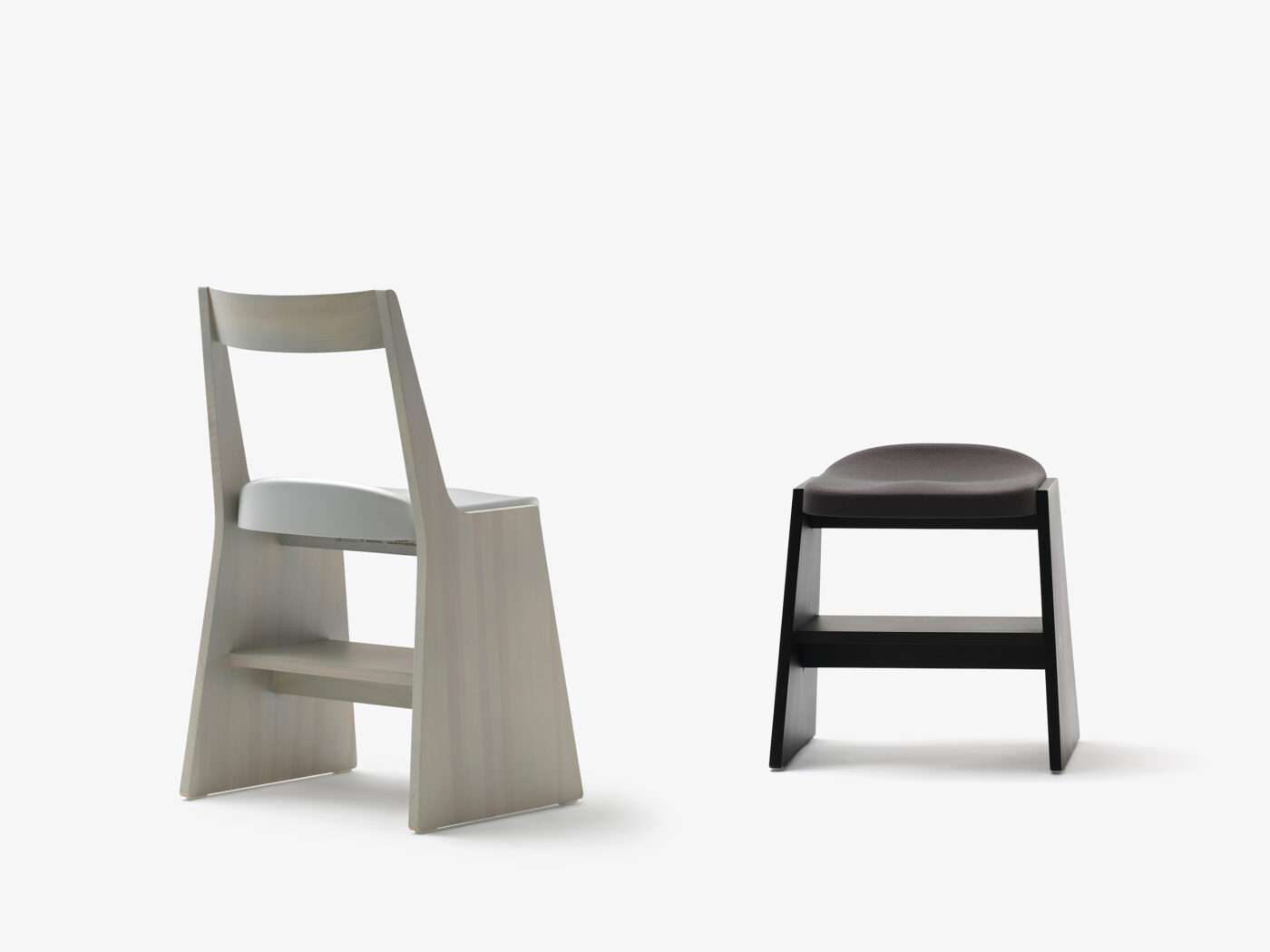Grey wooden chair with a tall back beside a low black stool