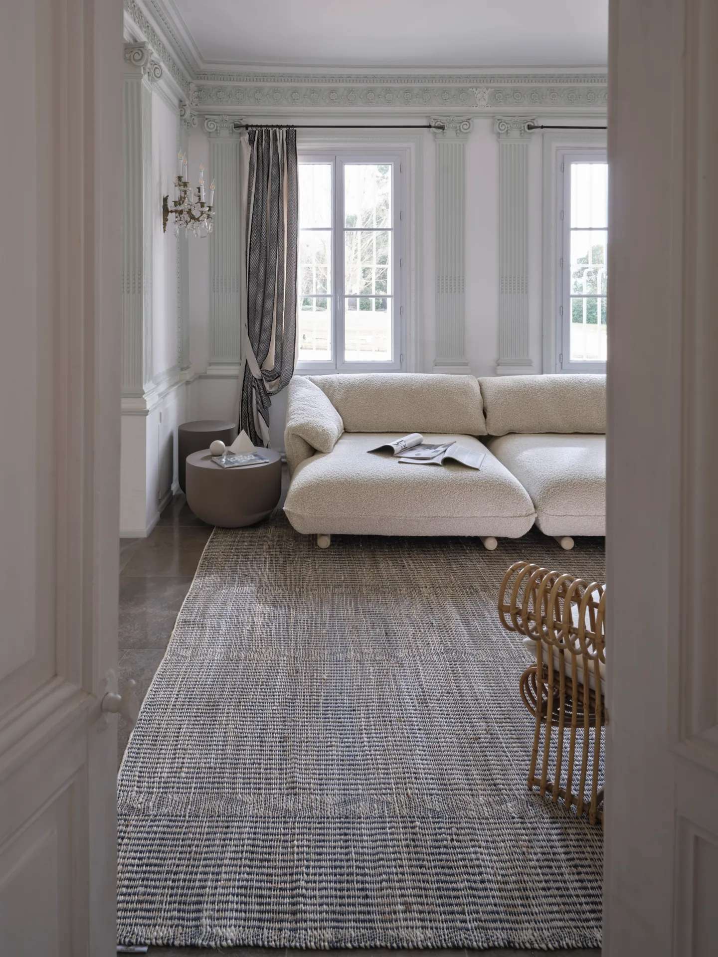 White modular sofa in a pale room with tall windows