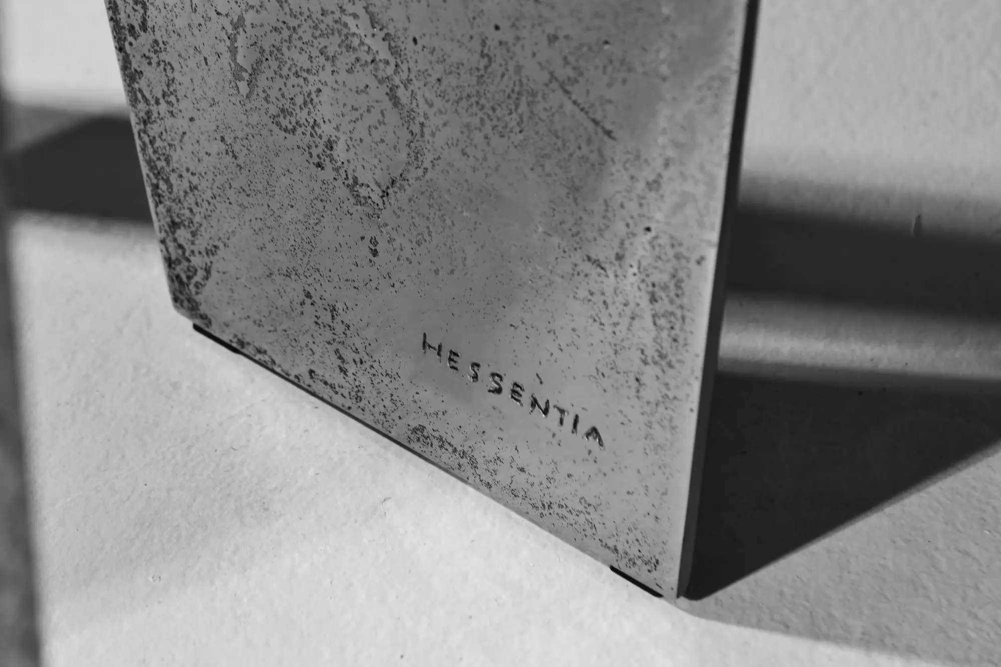 Hand-finished metal surface engraved with the Hessentia name