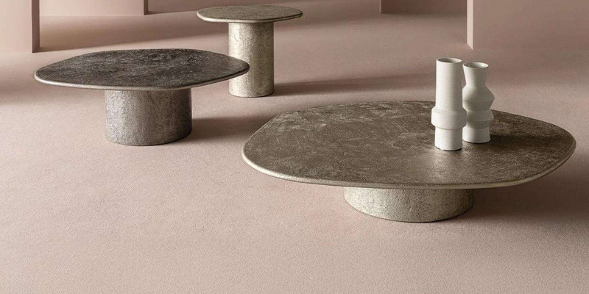 Round stone coffee tables of different heights on a blush floor