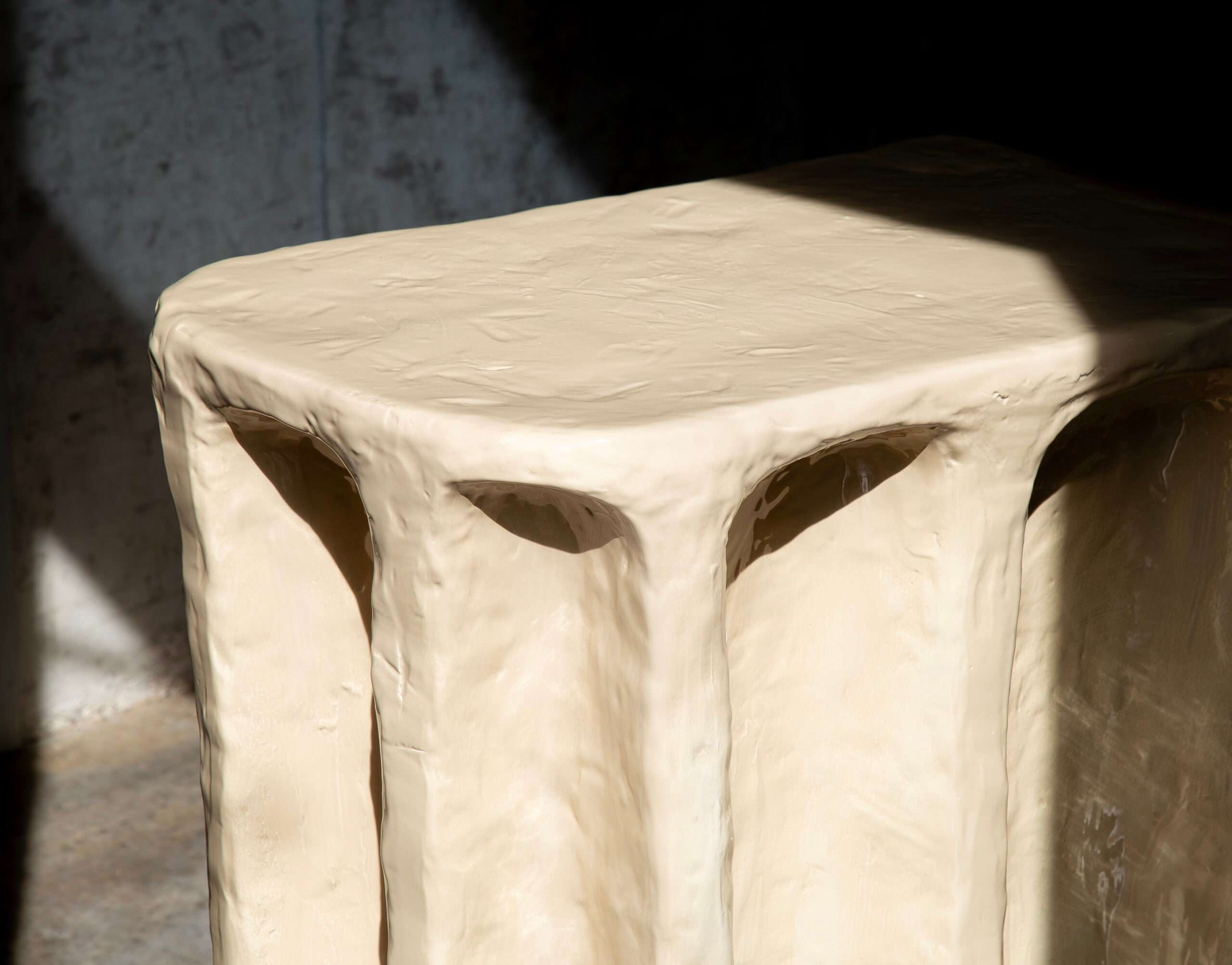 Top of a cream console with hand-shaped folds, in sunlight
