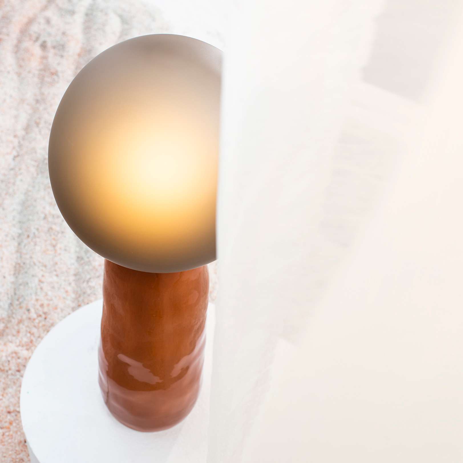 Glass globe lamp on a glossy orange base