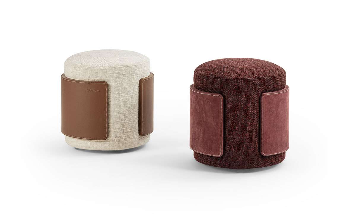 Round poufs wrapped in fabric with leather bands