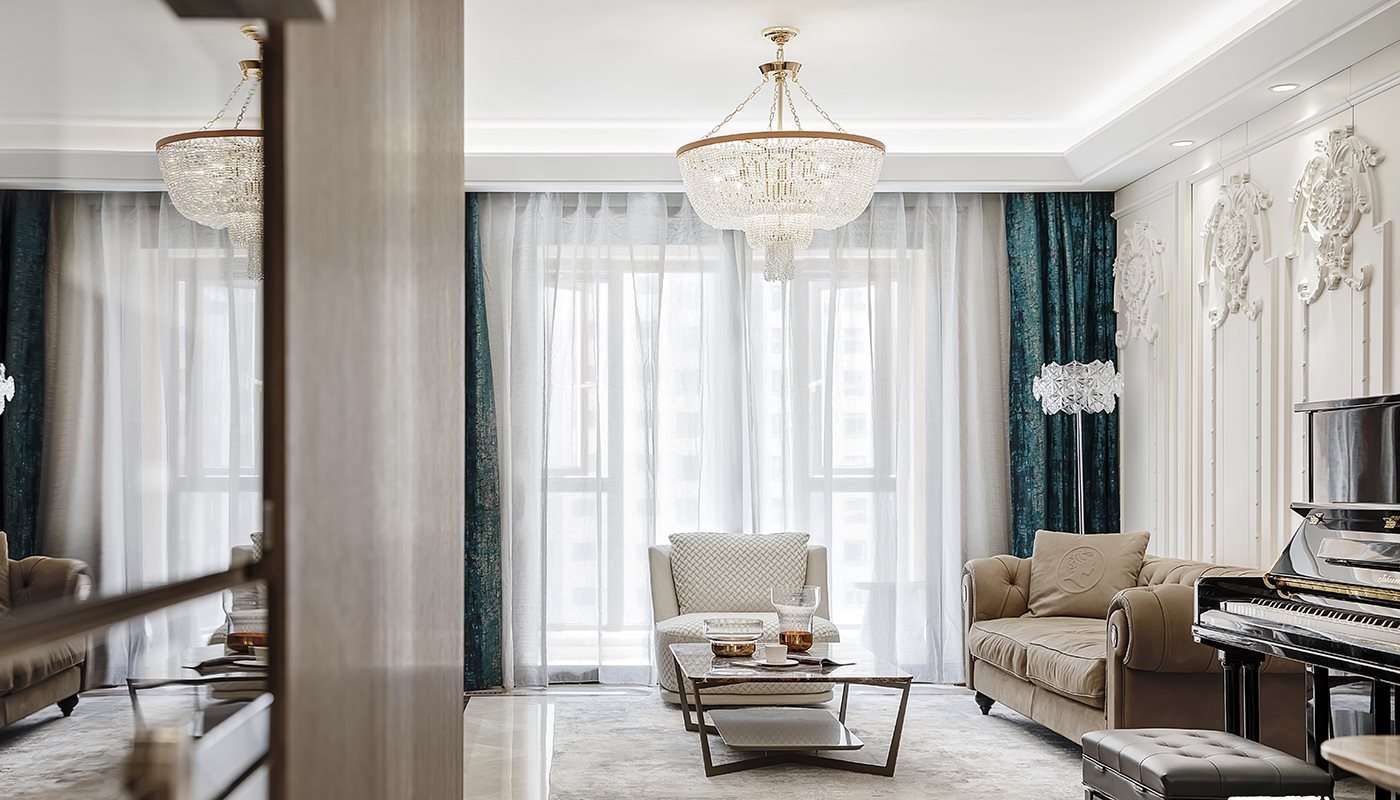 Classic sofa and armchairs beneath crystal chandeliers and long curtains