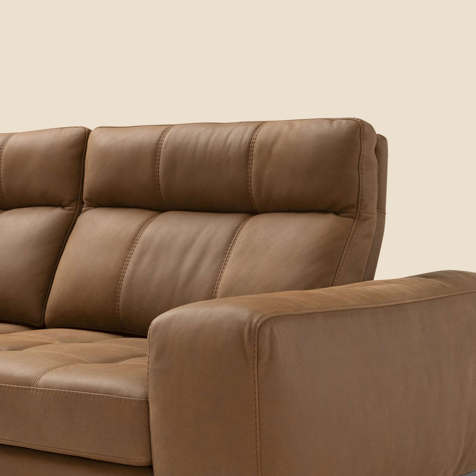 Detail of a brown leather sofa with stitched seat cushions